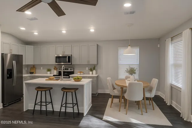 a kitchen with a dining table chairs and refrigerator