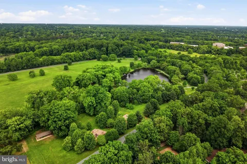 an aerial view of residential houses with outdoor space and trees