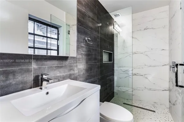 a bathroom with a sink toilet and shower