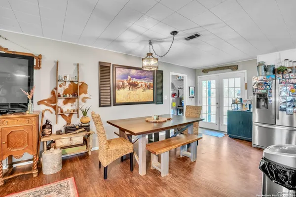 a room with furniture a flat screen tv and a dining table with kitchen view