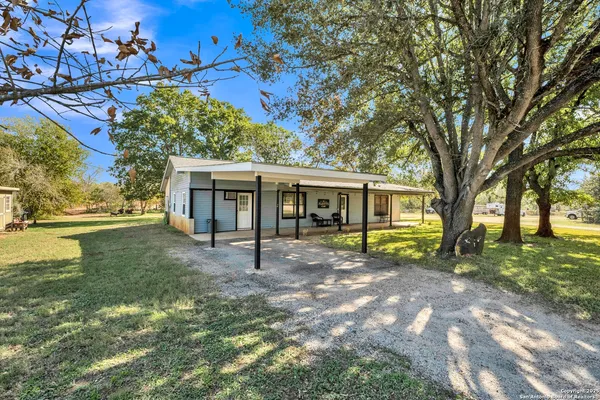 a view of a house with backyard and sitting area