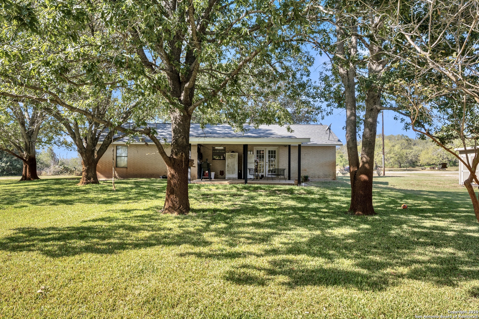 470 Rutledge Road Poteet, TX 78065 - Photo 27 of 40 a large tree in middle of the house next to a yard