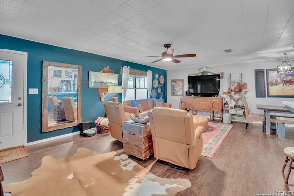 a living room with furniture flat screen tv and large window