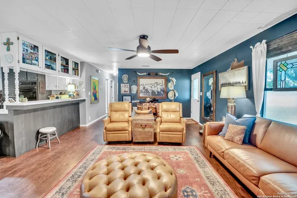 a living room with furniture and view of kitchen