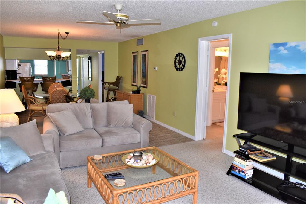 448 Cerromar Road, Unit 189 Venice, FL 34293 - Photo 19 of 48 a living room with furniture a flat screen tv and kitchen view