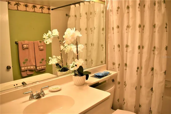 a bathroom with a sink mirror and a shower