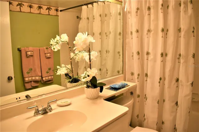 a bathroom with a sink mirror and a shower