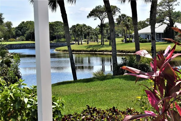a view of a lake with a bench and trees around