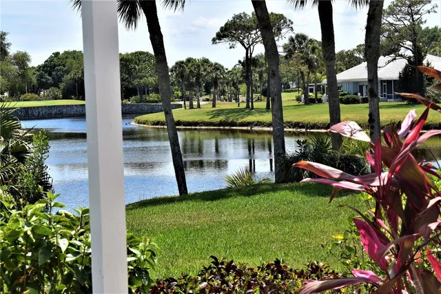 a view of a lake with a bench and trees around