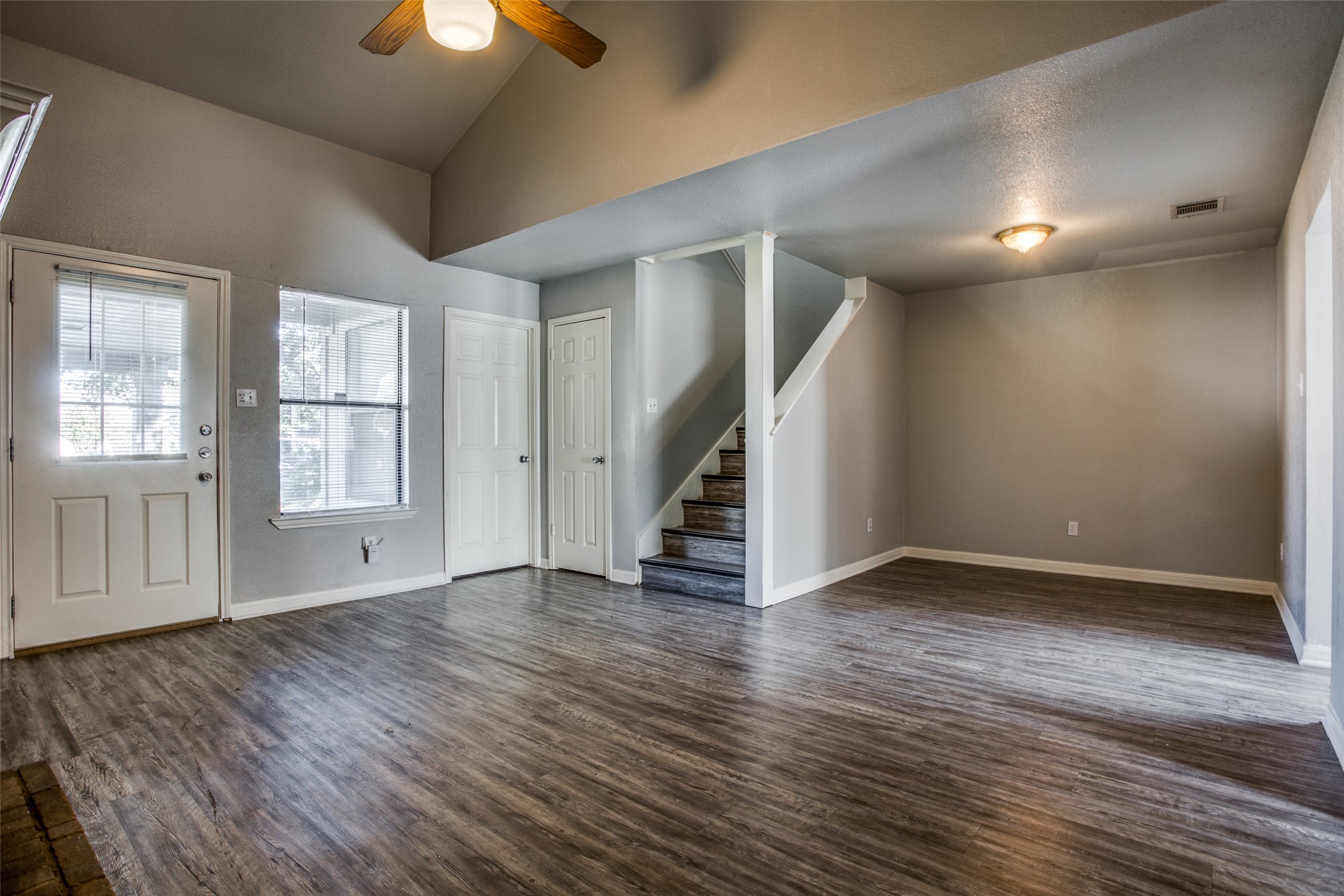 106 Verna Spur, Unit B Georgetown, TX 78628 - Photo 6 of 25 A spacious living area featuring vaulted ceilings and durable plank flooring.