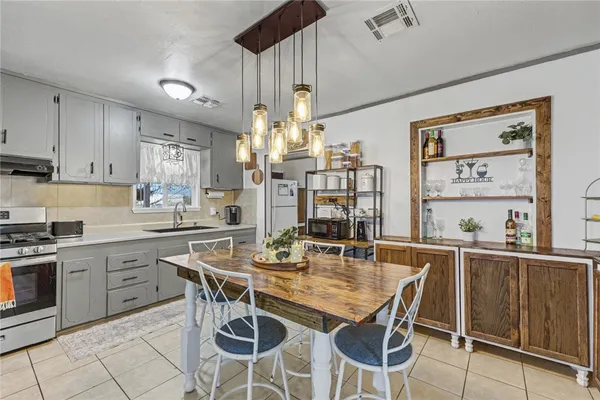 a kitchen with stainless steel appliances kitchen island granite countertop a table and chairs in it