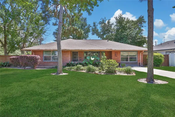 a front view of a house with a yard and green space