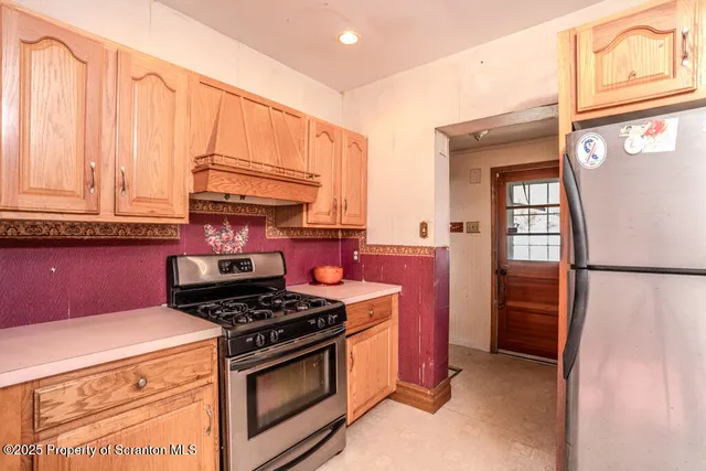 a kitchen with stainless steel appliances granite countertop a refrigerator a sink and cabinets