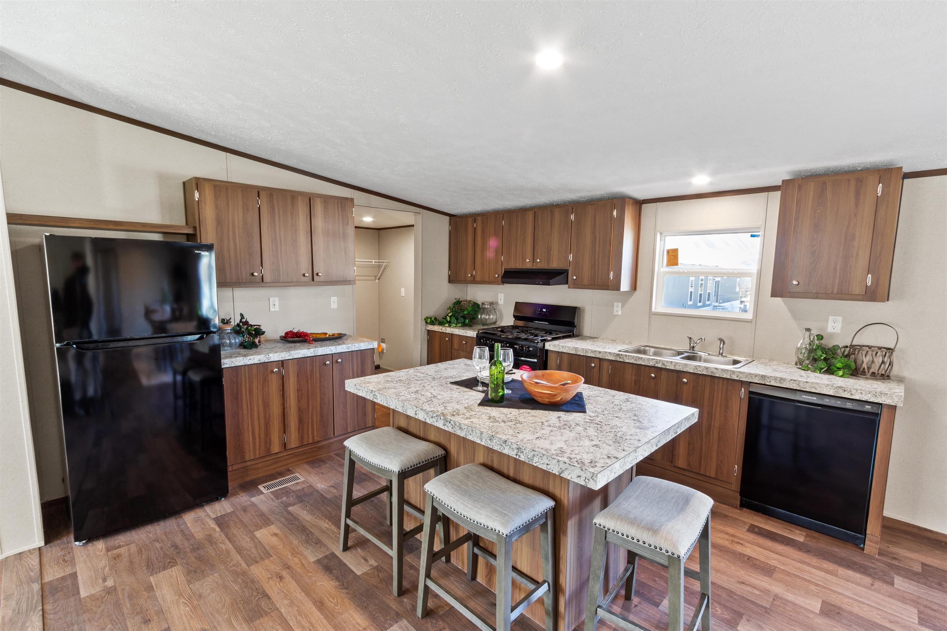 133 West Carson Circle Parachute, CO 81635 - Photo 23 of 25 a kitchen with stainless steel appliances granite countertop a refrigerator a stove a sink a dining table and chairs with wooden floor
