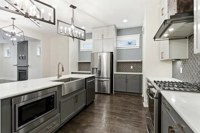 a kitchen with stainless steel appliances a stove a sink and a refrigerator