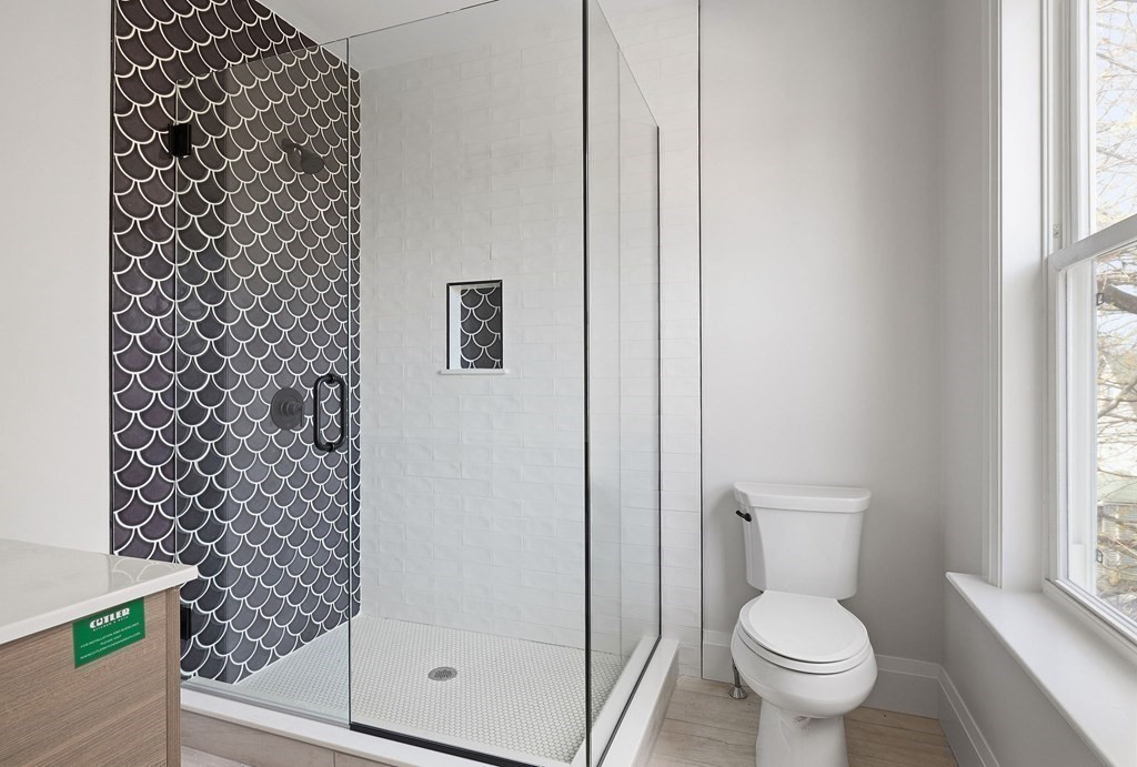 849 Cummins Highway, Unit 3 Boston, MA 02126 - Photo 4 of 7 a bathroom with a toilet and a shower curtain