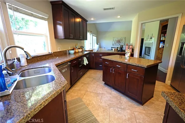 a bathroom with a granite countertop shower a sink and a mirror