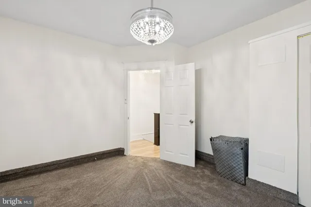 an empty room with a chandelier fan