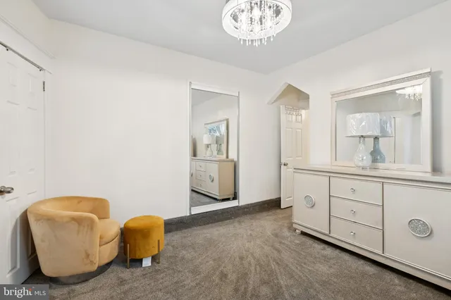 a spacious bedroom with a bed and a chandelier