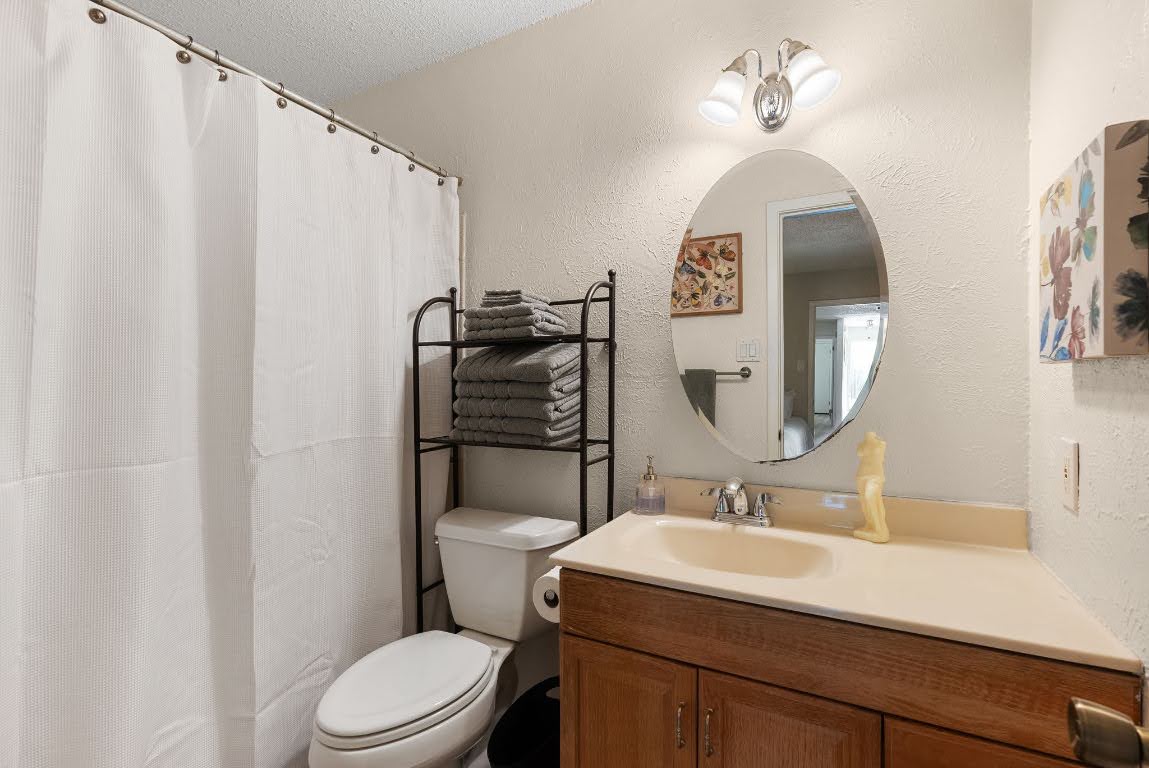 2320 Montclaire Street, Unit A Austin, TX 78704 - Photo 27 of 36 a bathroom with a toilet a sink and a mirror