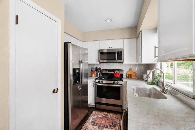 a kitchen with microwave a stove and a refrigerator