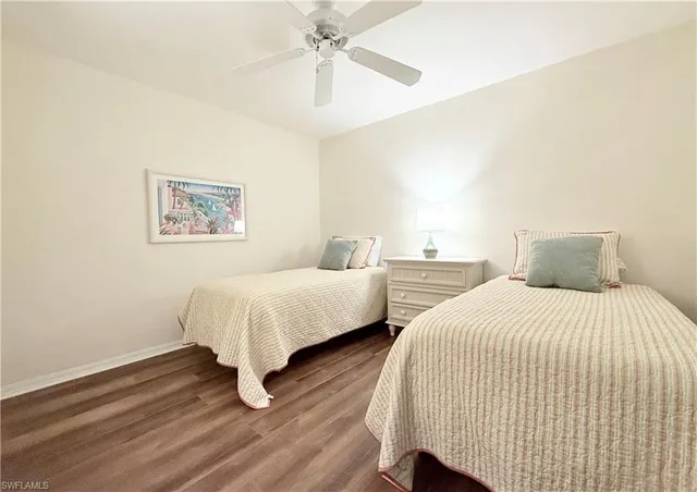 a spacious bedroom with two beds and painting on the wall