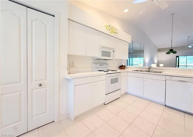 a kitchen with white cabinets and white appliances