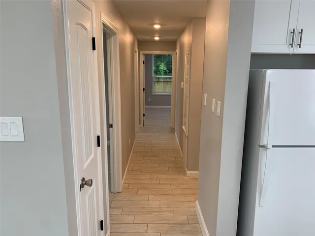 a view of a hallway with wooden floor