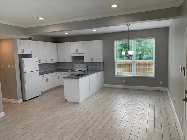 a kitchen with wooden floors and white appliances