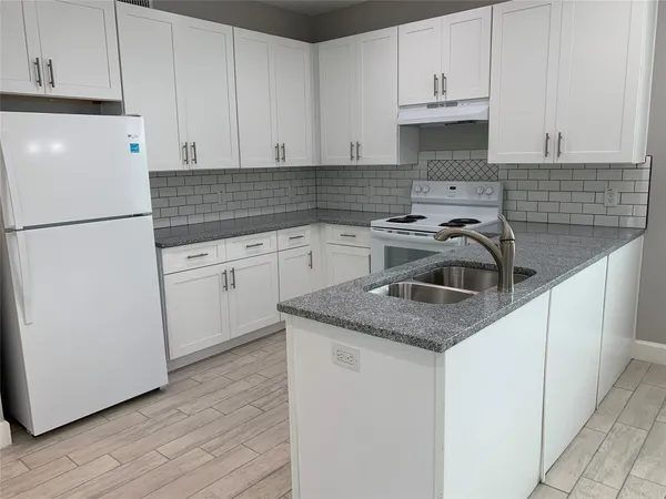 a kitchen with appliances a sink and cabinets