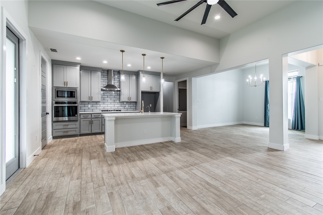 4801 Del Paseo Street Corpus Christi, TX 78411 - Photo 19 of 36 a large kitchen with stainless steel appliances kitchen island a large counter top and wooden floors