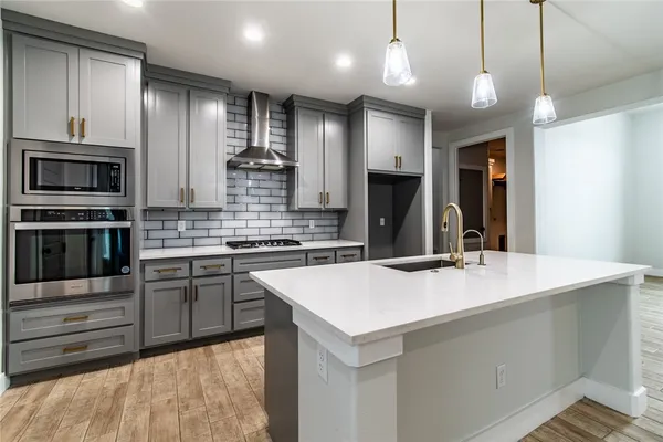 a kitchen with kitchen island a sink stainless steel appliances and cabinets