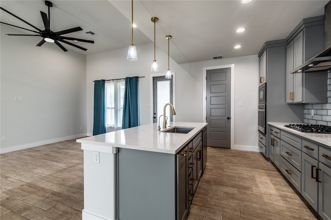 4801 Del Paseo Street Corpus Christi, TX 78411 - Photo 27 of 36 a kitchen with kitchen island a sink appliances and cabinets