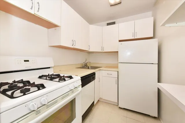 a kitchen with a white stove and white cabinets