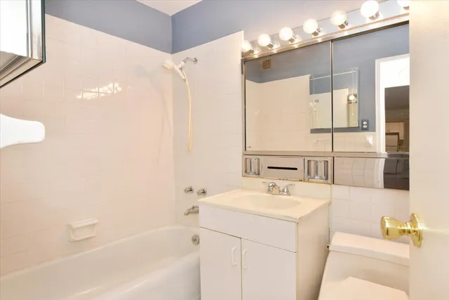a bathroom with a sink a tub and a mirror