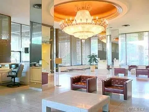 a very nice looking living room with a large window and chandelier