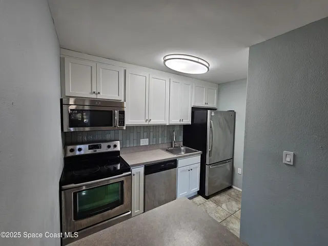 a kitchen with stainless steel appliances granite countertop a stove a refrigerator and a microwave