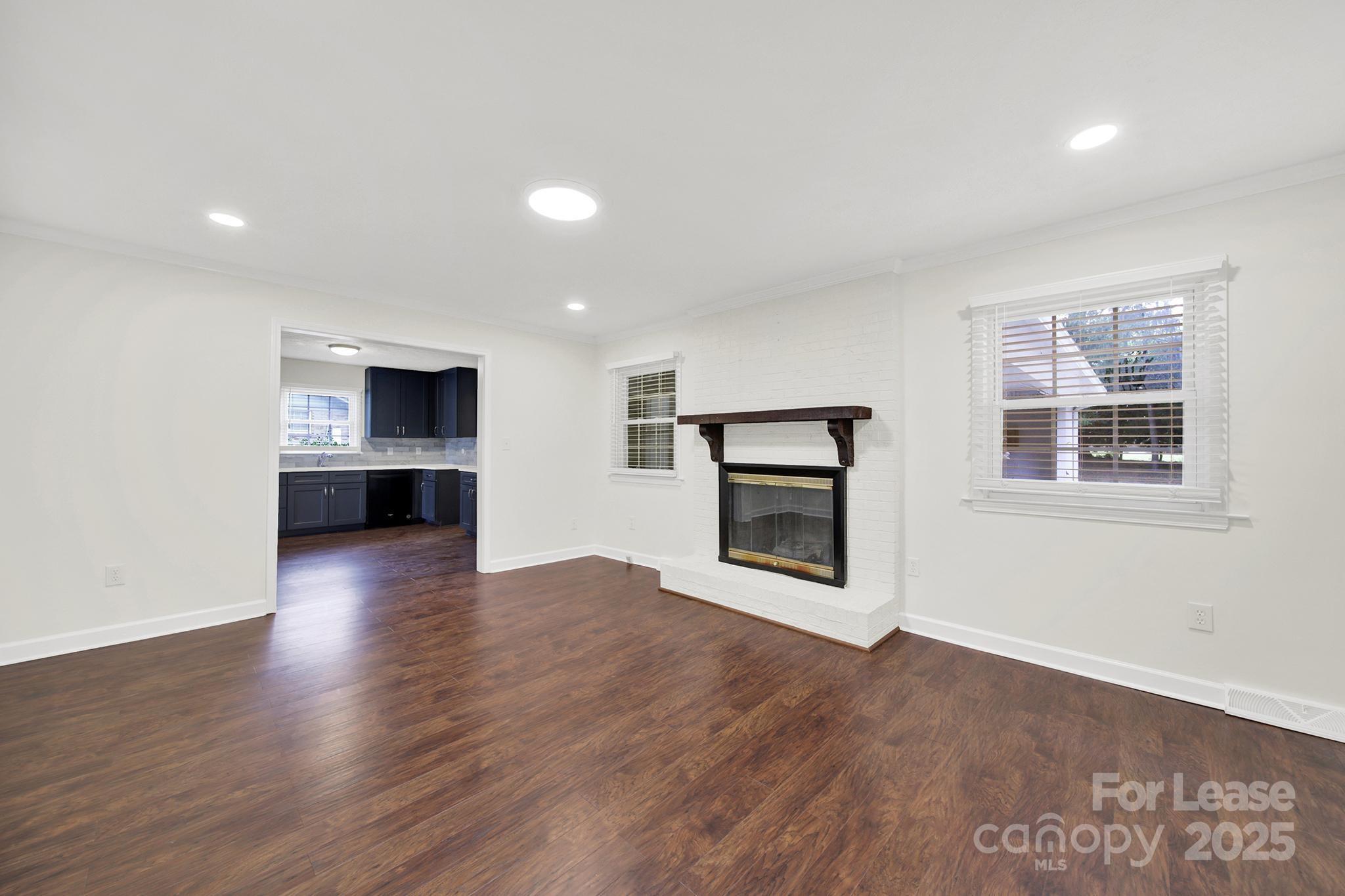 2400 Fox Hollow Road Mint Hill, NC 28227 - Photo 14 of 32 an empty room with wooden floor and a fireplace