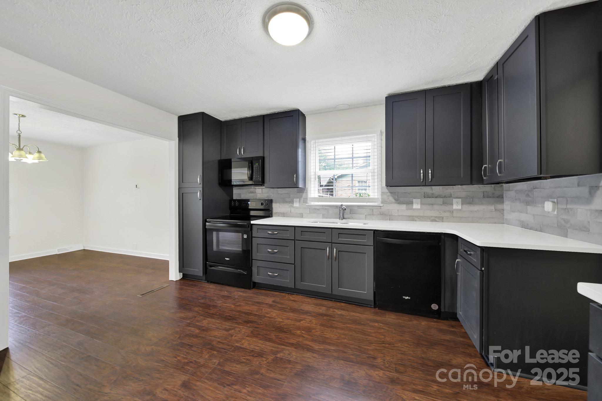 2400 Fox Hollow Road Mint Hill, NC 28227 - Photo 9 of 32 a kitchen with granite countertop a stove cabinets and a sink