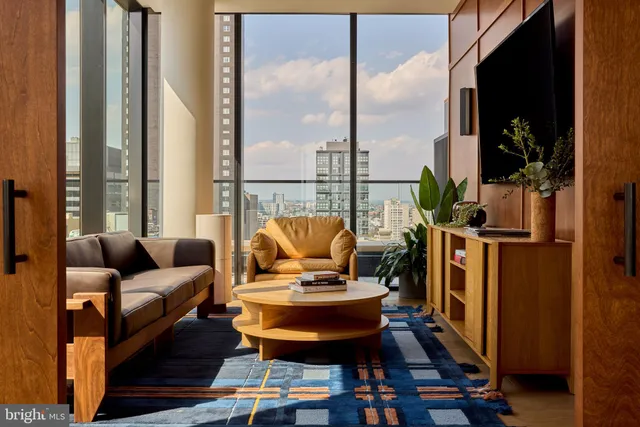 a living room with furniture and floor to ceiling windows