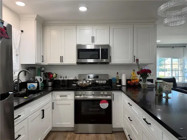 a kitchen with stainless steel appliances granite countertop a refrigerator a stove a sink and a oven
