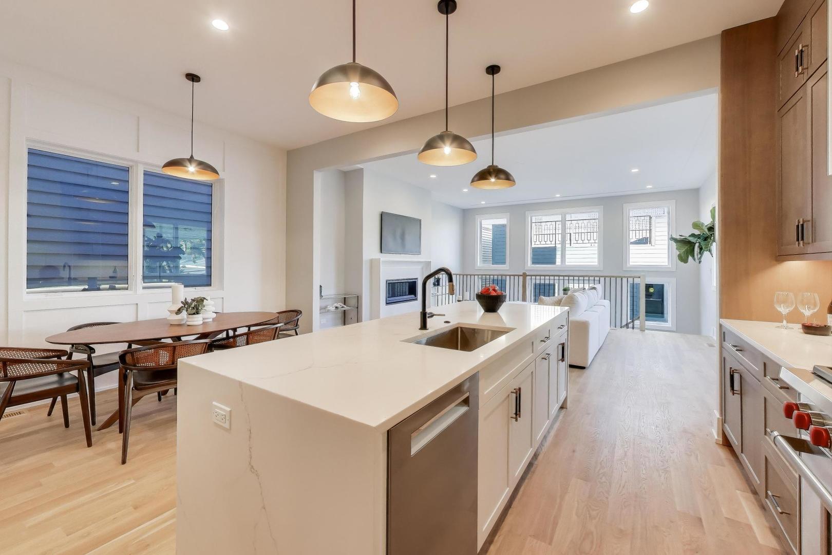 3929 North Francisco Avenue Chicago, IL 60618 - Photo 11 of 47 a large kitchen with kitchen island a stove a counter a sink a dining table and chairs