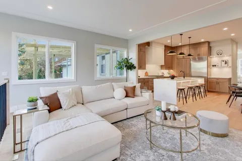 a living room with furniture kitchen and a large window