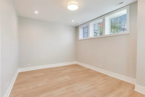 an empty room with windows and refrigerator