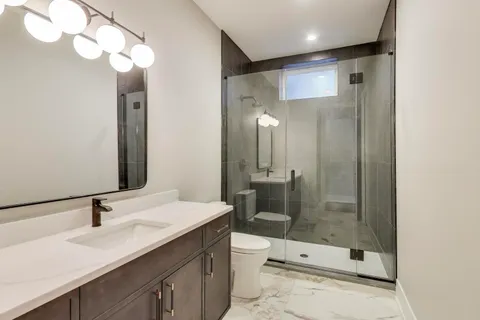 a bathroom with a sink a toilet and shower