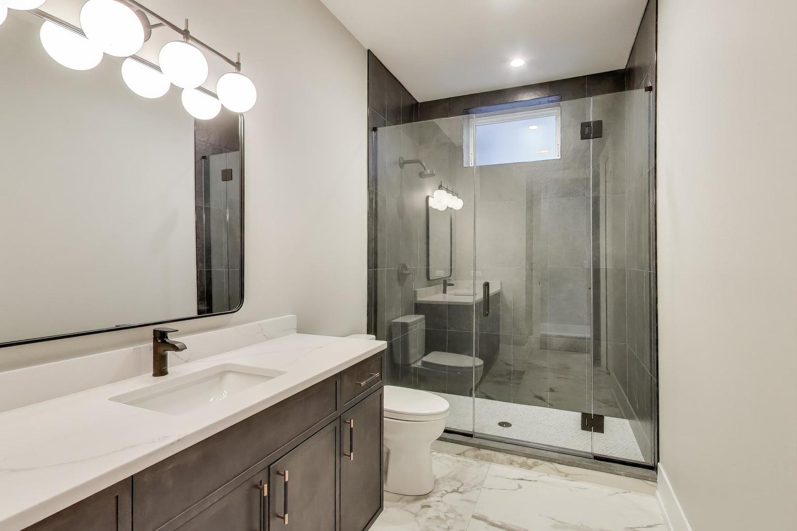 3929 North Francisco Avenue Chicago, IL 60618 - Photo 40 of 47 a bathroom with a sink a toilet and shower