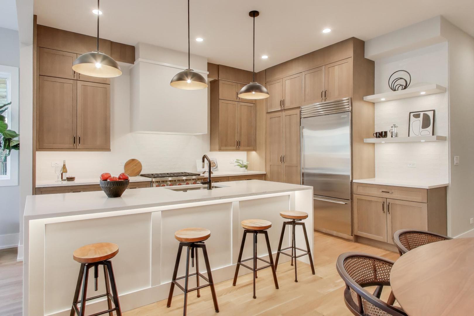 3929 North Francisco Avenue Chicago, IL 60618 - Photo 7 of 47 a kitchen with stainless steel appliances kitchen island a table chairs refrigerator and sink