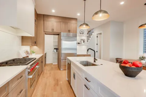 a kitchen with stainless steel appliances a sink a stove and a wooden floors