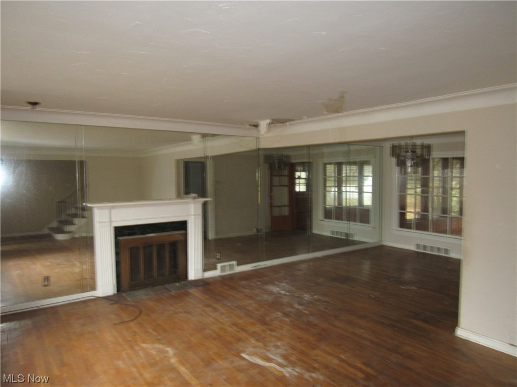 2350 North Taylor Road Cleveland, OH 44112 - Photo 5 of 24 Unfurnished living room featuring dark hardwood / wood-style flooring and crown molding