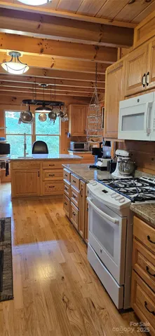a kitchen with stainless steel appliances granite countertop a stove and a wooden cabinets